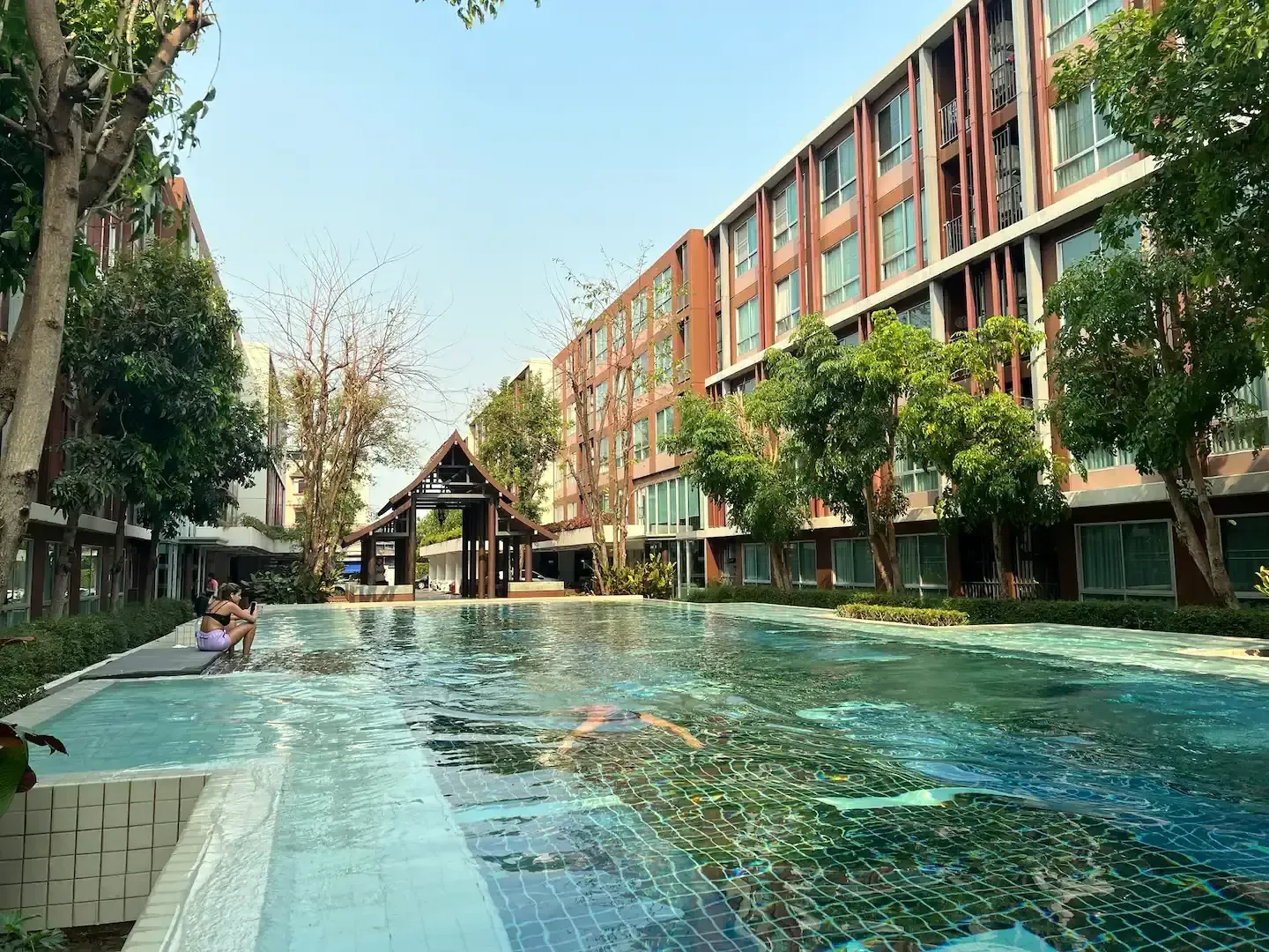 Outdoor saltwater swimming pool surrounded by modern condo buildings